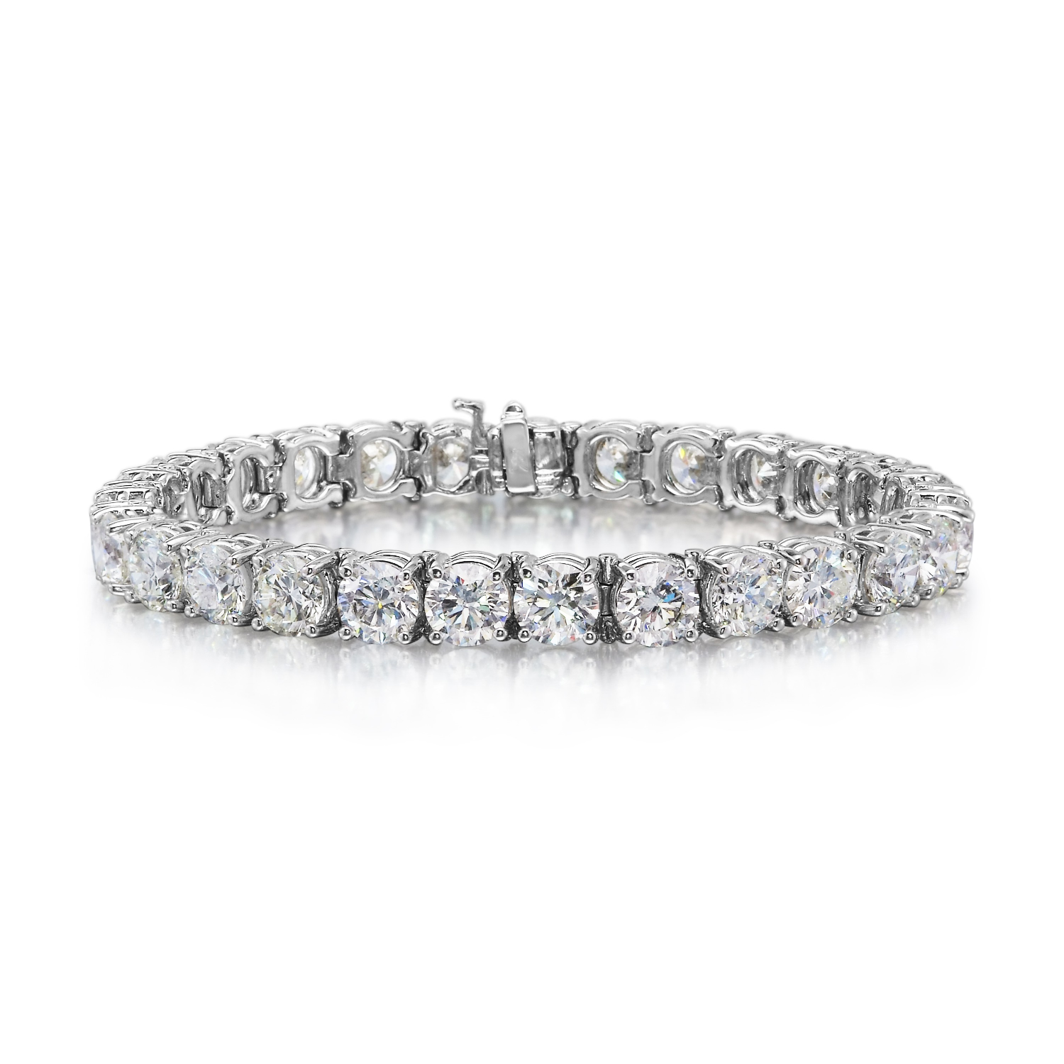 A silver tennis bracelet set with round-cut clear gemstones, photographed on a clean white background with a soft reflection.